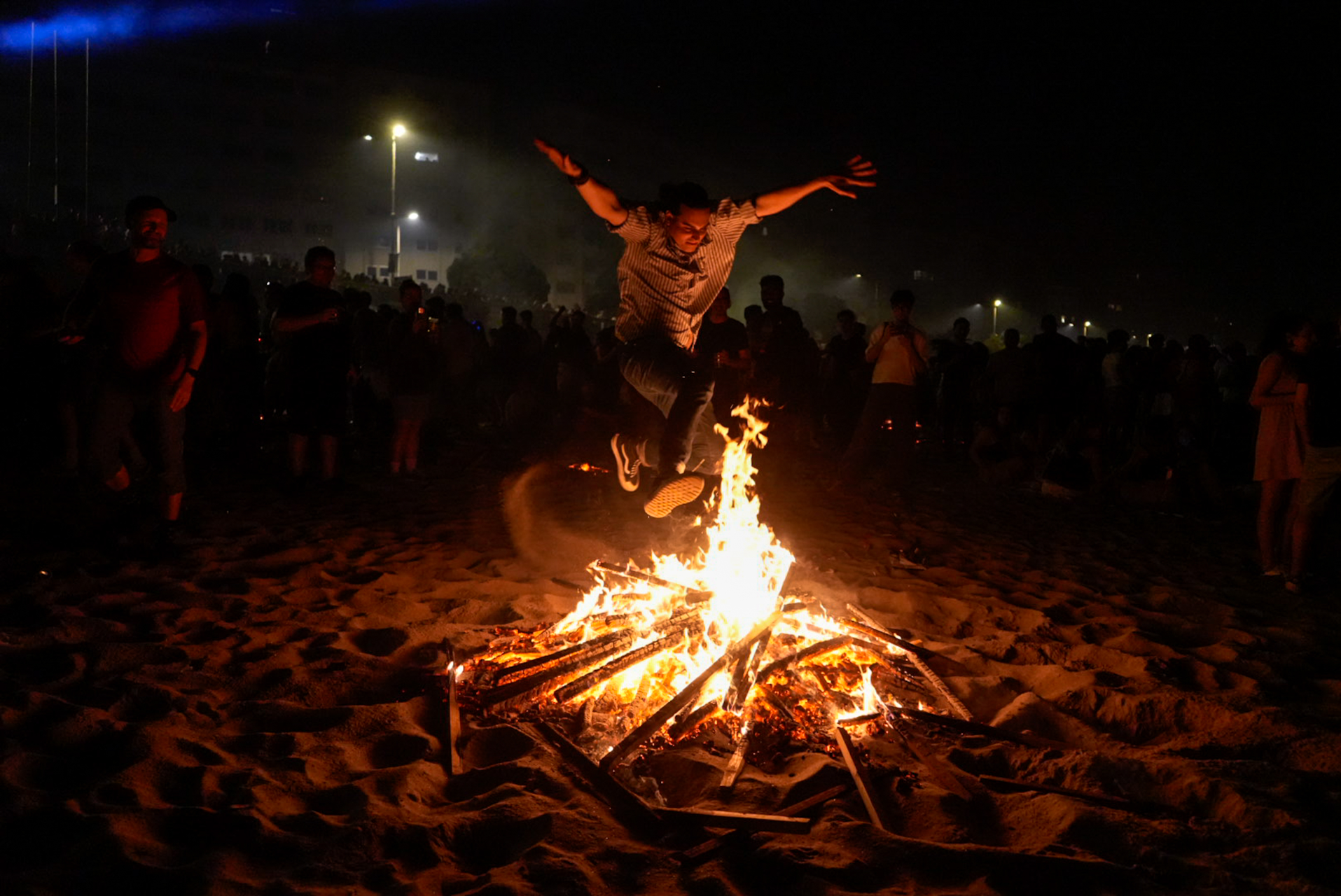 A man jumping over a bonfire in A Coruña